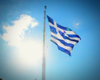 Low angle view of flag against blue sky