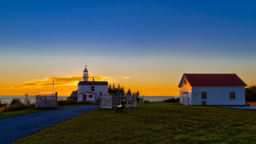 House on beach against sky during sunset