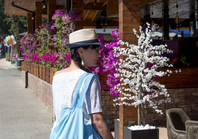 Woman standing by flowering plants