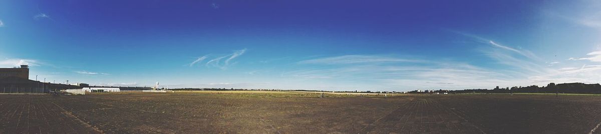 Panoramic view of field against cloudy sky