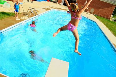 Woman jumping into swimming pool