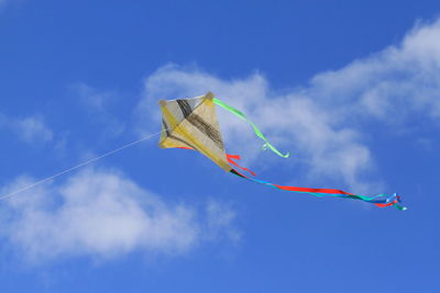 Low angle view of kite flying against blue sky