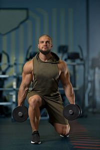 Portrait of young man exercising in gym