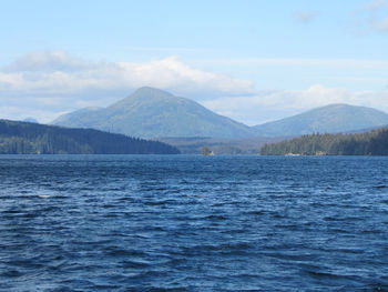 Scenic view of sea by mountains against sky
