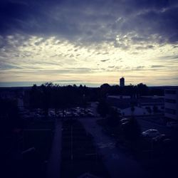 Silhouette city against sky at sunset