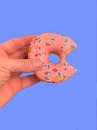 Midsection of person holding ice cream against blue background