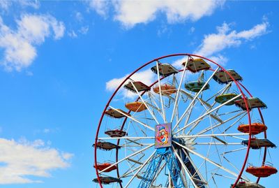 Low angle view of ferris wheel against blue sky