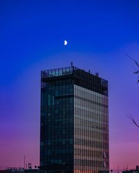 Low angle view of modern buildings against sky during sunset