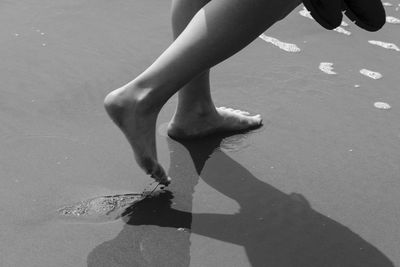 Low section of person with shadow at beach