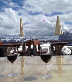 Lounge chairs and tables at table against sky