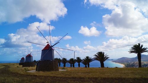 Traditional windmill on field against sky