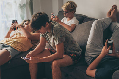 Young man using mobile phone at home