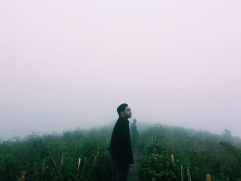 Young man standing on land against sky