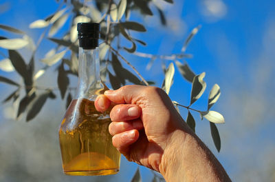 Close-up of hand holding glass bottle