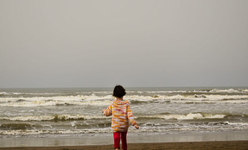 Rear view of boy standing on beach