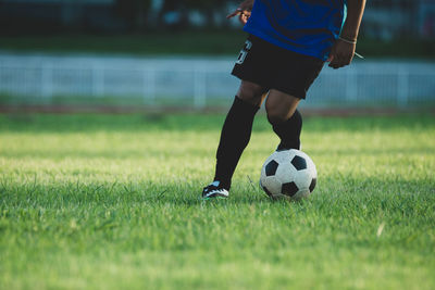 Low section of woman playing soccer on field