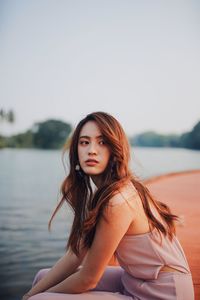 Portrait of beautiful woman against sky