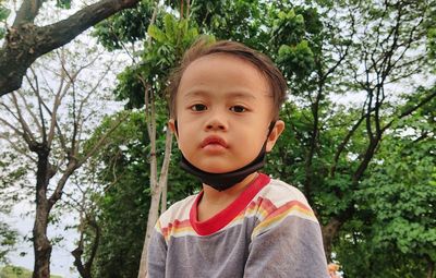 Portrait of cute boy against trees