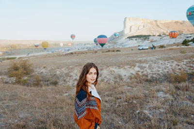 Young woman with balloons on field