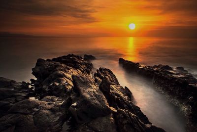 View of calm beach at sunset