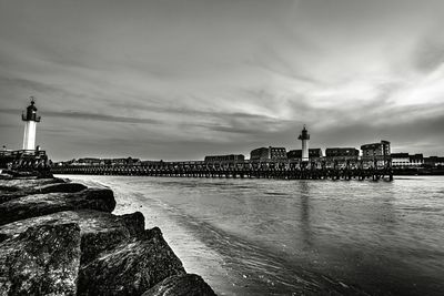 Lighthouse by sea against sky