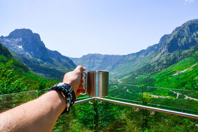 Midsection of man on mountain against clear sky