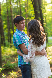 Couple kissing against blurred trees