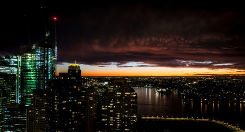 Illuminated buildings in city against sky at night
