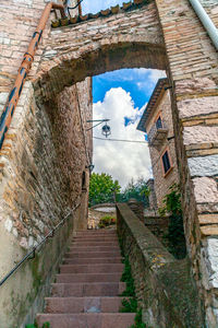 Low angle view of steps amidst buildings against sky