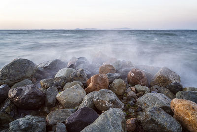 Rocks in sea against sky