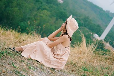 Side view of woman lying on field