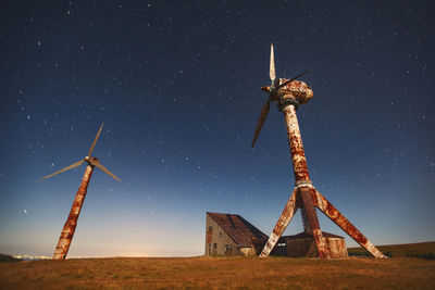 Low angle view of windmill on field against sky at night