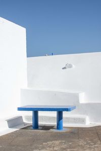 Bench against building against clear blue sky