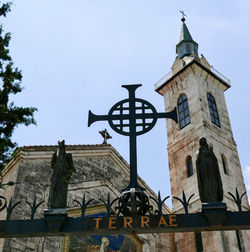 Low angle view of clock tower amidst buildings against sky