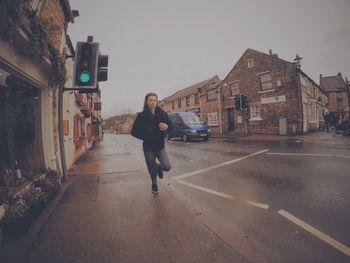 Full length of woman walking on road in city