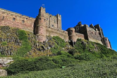 Low angle view of castle against clear blue sky