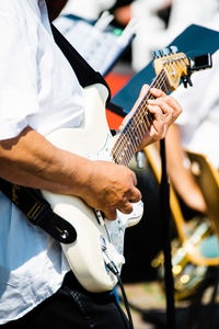 Midsection of man playing guitar