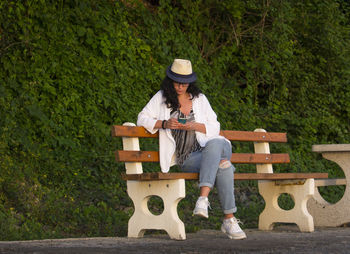 Full length of young man sitting on bench