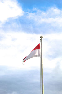 Low angle view of flag flags against sky