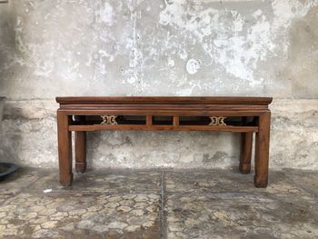 Empty chair and table against wall