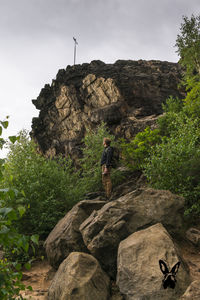 Man standing on cliff against sky