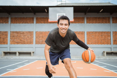 Portrait of man playing with basketball