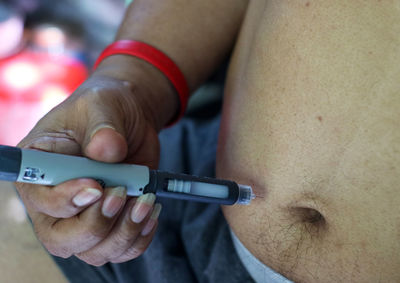 Close-up of man taking injection