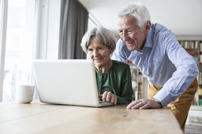 Senior couple using laptop at home