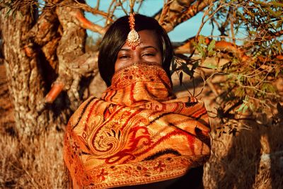 Close-up portrait of female model wearing traditional clothing by tree