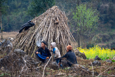 People sitting on ground in forest