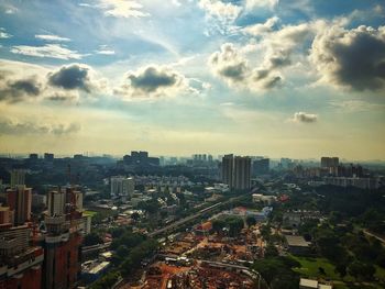 Aerial view of city against cloudy sky