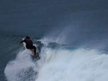 Man surfboarding in sea against sky