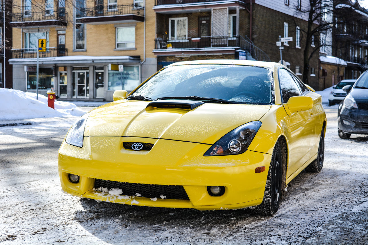 VIEW OF YELLOW CAR ON STREET