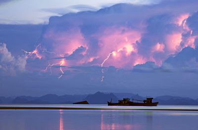 Silhouette boats in sea against sky during sunset